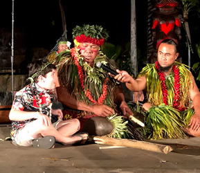 Chief Sielu, of Chief's Luau, talks with a small child on stage. Chief's Luau os one of the best kid-friendly luaus on Oahu.