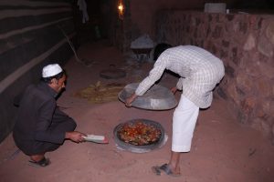 Bedouin men tending an underground oven