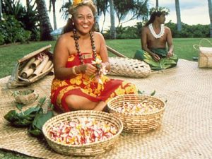 Luau attendants wait with baskets of fresh flowers, ready to teach  guests the art of lei making during the luau's arts and crafts period.