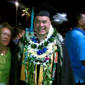 Happy Hawaiian graduate with many leis.