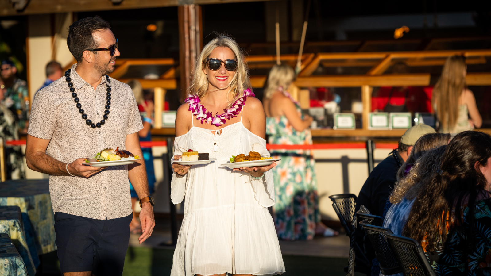 Woman holding two plates of food at a luau