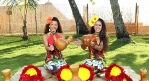 Two women hula performers playing the ipu at the Diamond Head Luau, Waikiki.