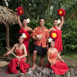 Luau cast members pose in traditional Hawaiian dress with instruments. 