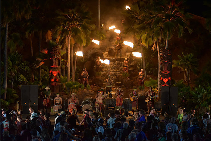 Fire knife dancers and the luau's Hawaiian band fill a huge stage with palm trees and a volcano backdrop.