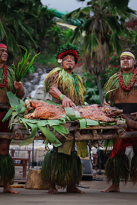 The Chief stands with a whole roasted pig, the highlight of the luau buffet. 