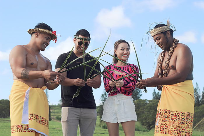 Guests learn to weave grass headbands from staff at a luau in Hawaii. 