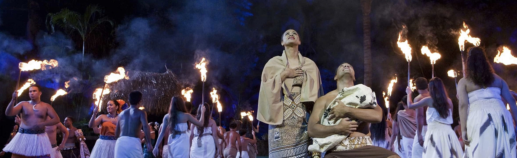 The cast of Ha: Breath of LIfe performs on stage with lit torches.