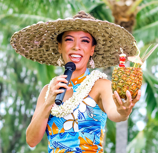 Keeley, DIamond Head Luau's emcee, promotes the drinks served in pineapples.