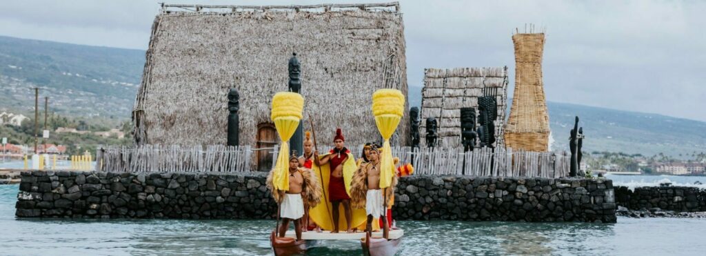 Luau performers reenact a floating procession with King Kamehameha in Kailua-Kona.