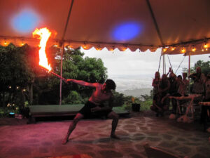 A fire knife dancer performs under a tent at luau in Hawaii.