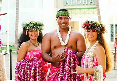 Smiling luau staff prepare to greet guests with flower leis at Aloha Tower.