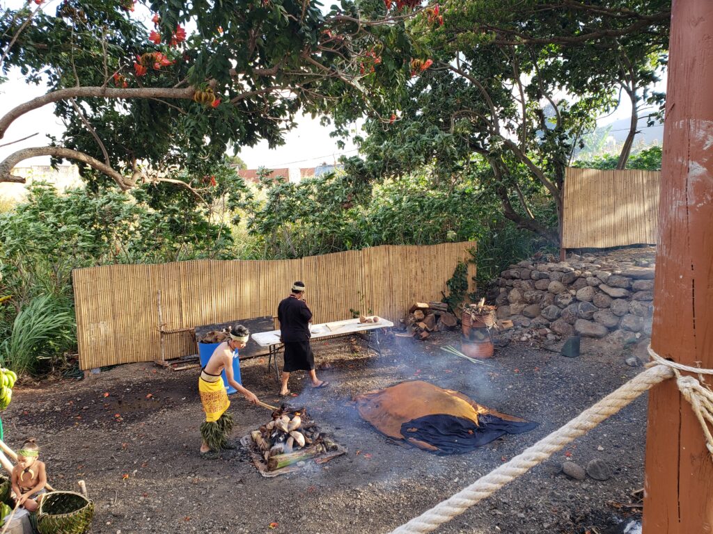 Staff tend to the underground ovens at Mauka Warriors Luau.