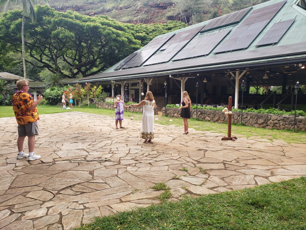 Guests take a poi-ball twirling lesson at the Toa Luau, cultural activities make it one of the most authentic luaus on Oahu. 
