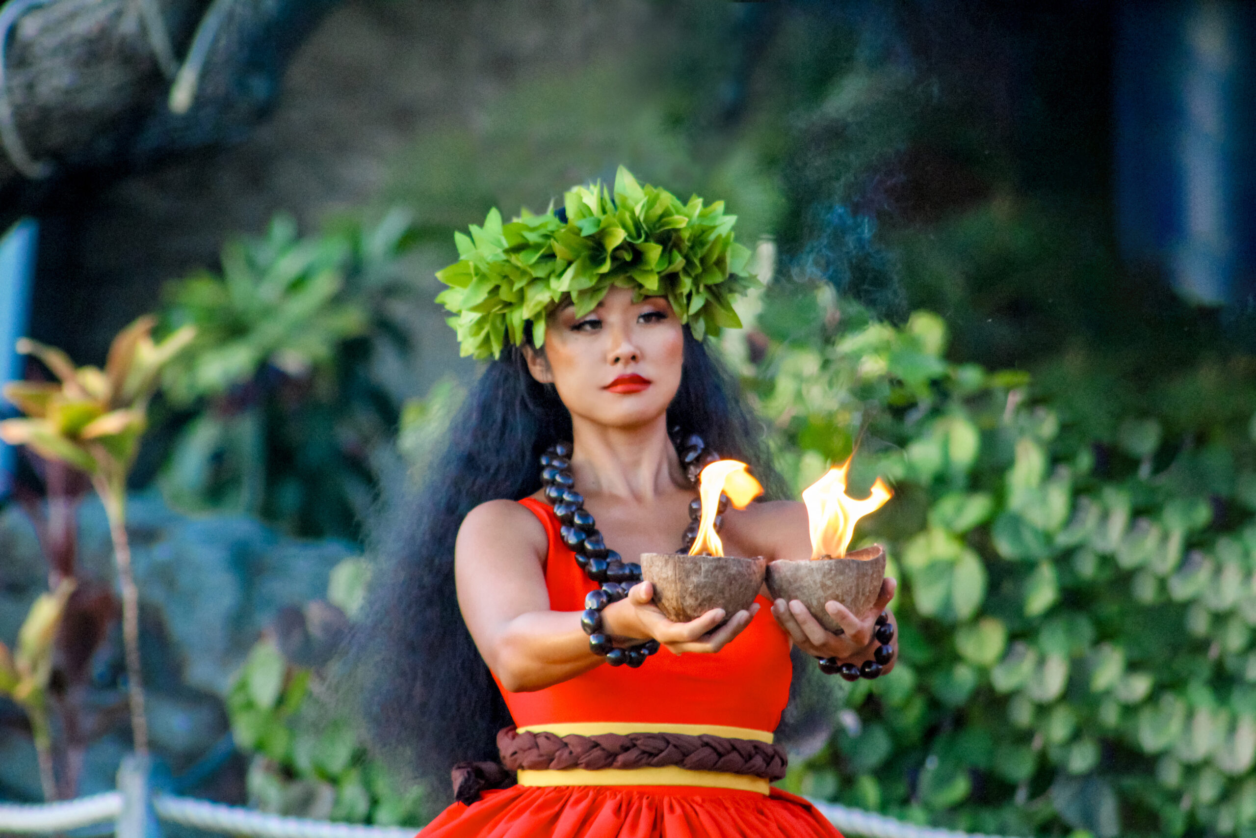 Hula dancer presents fire in two coconut shells at Diamond Head lual.