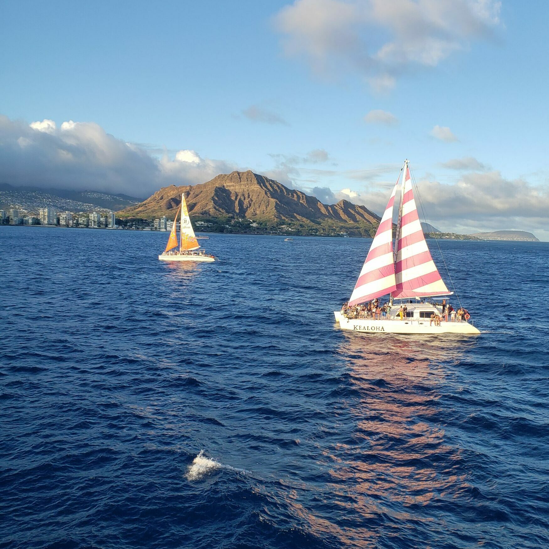 Ships sail Waikiki Harbor with Diamond Head Crater in the background