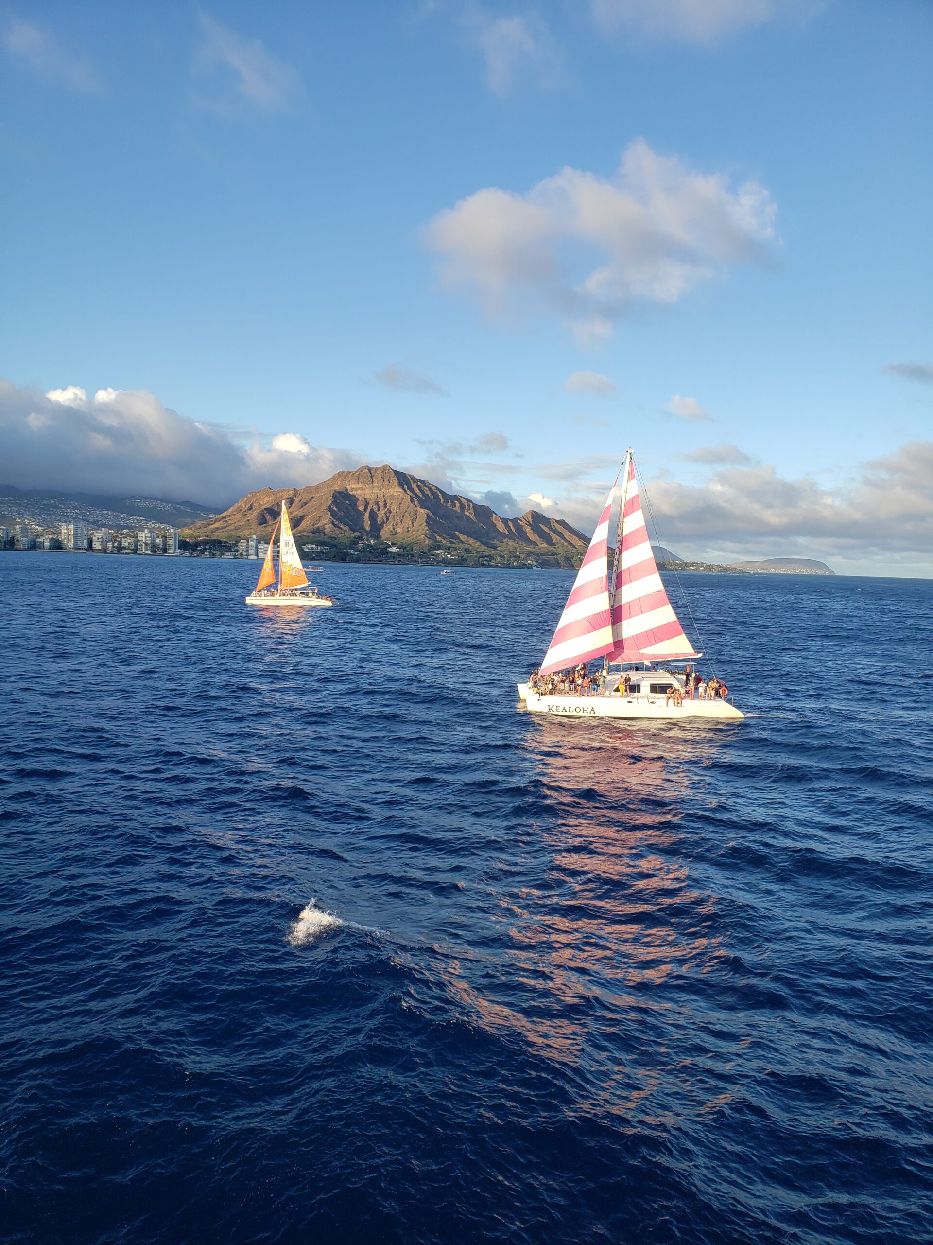 Ships sail Waikiki Harbor with Diamond Head Crater in the background
