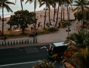 Aerial view of a shuttle bus making a hotel pick-up in Waikiki Beach from one of the many luaus that offer transportation.